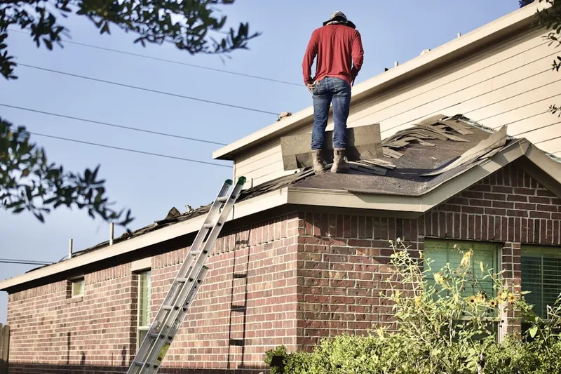 Professional roofer working on a residential roof in Ashland Place